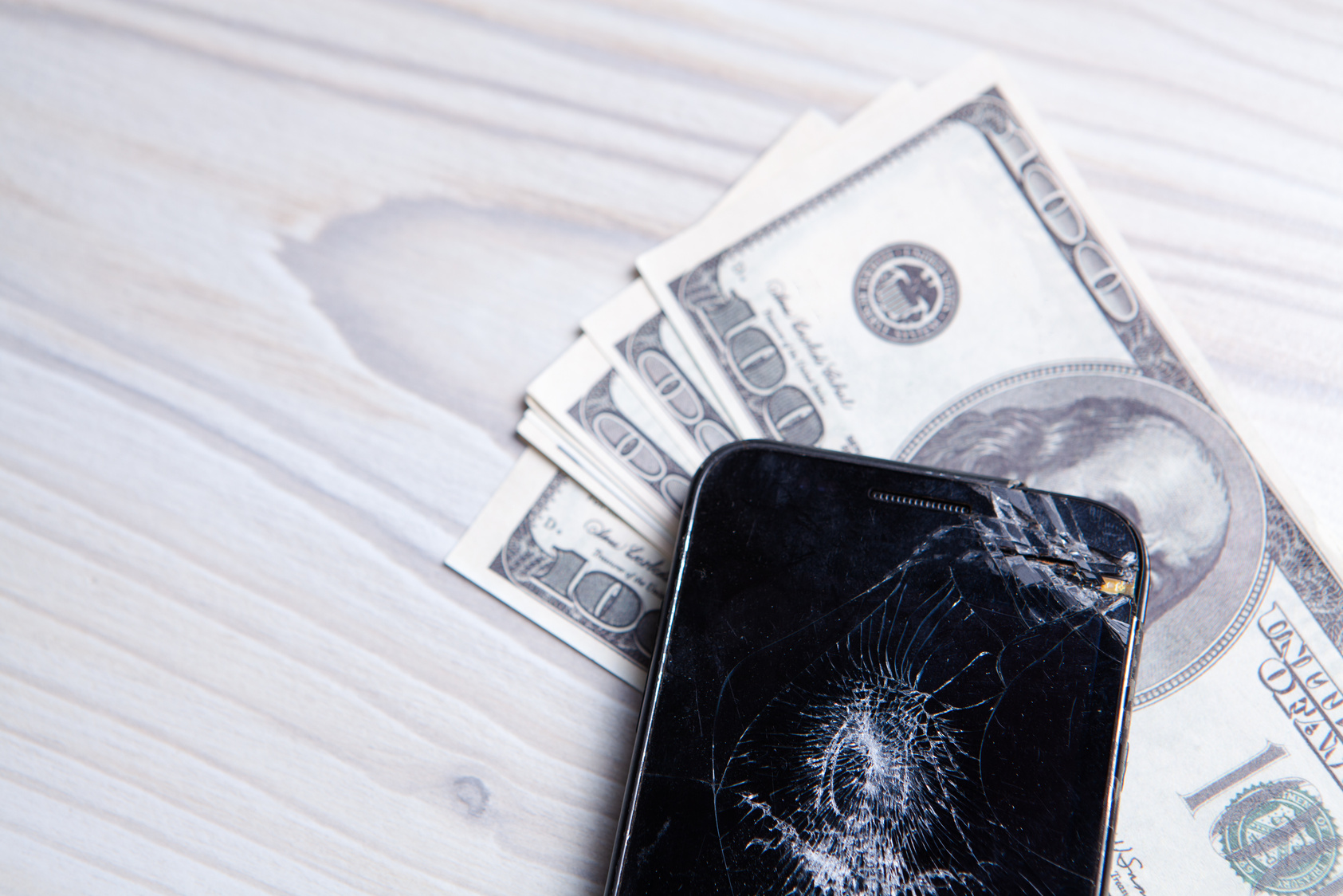 Modern broken mobile phone and dollars